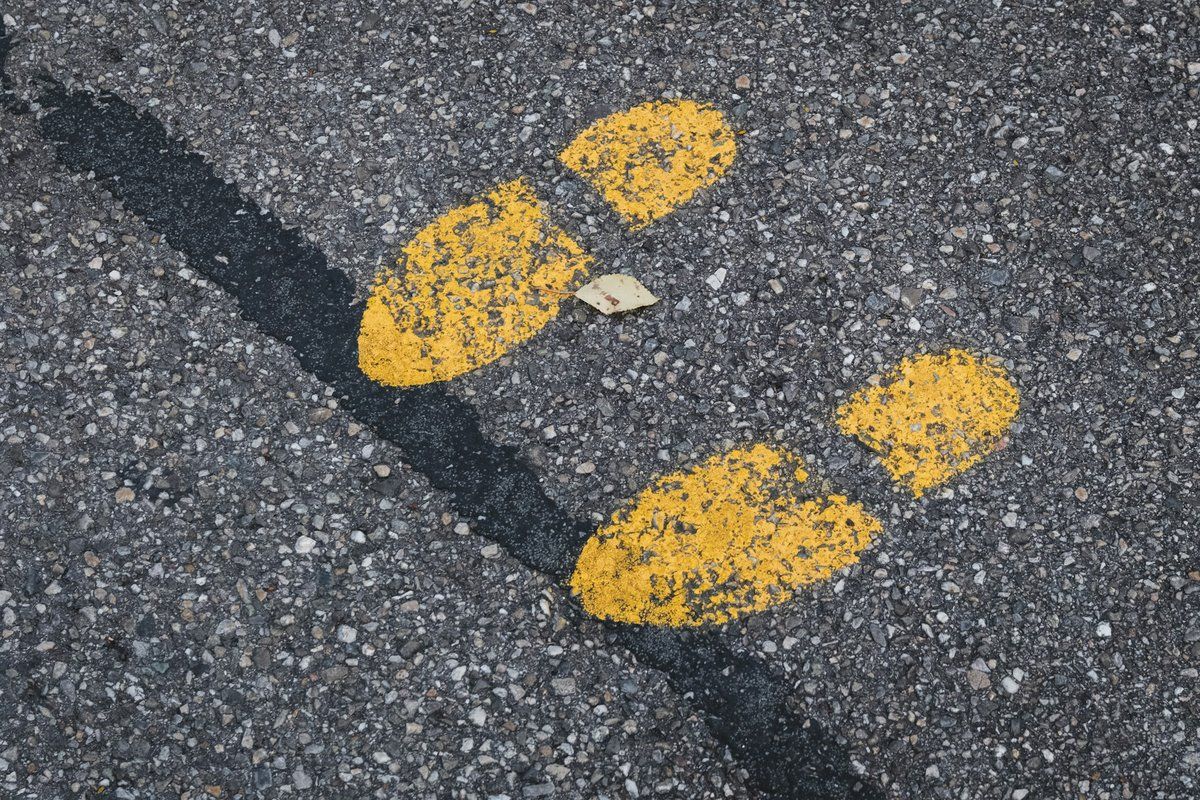 Empreintes de pas peintes en jaune sur l'asphalte