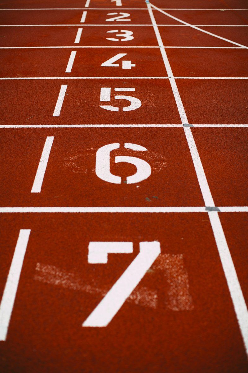 Numéros de couloirs peints sur une piste d'athlétisme rouge